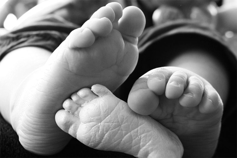 Wee little baby feet, showing off their much smaller foot magnet made as a newborn